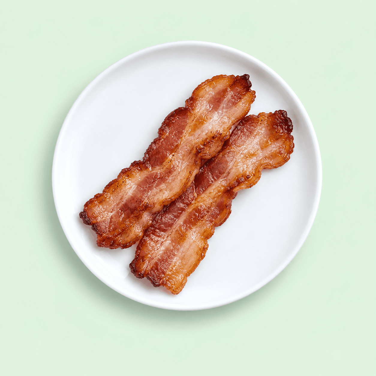 Three crisp strips of bacon on a white plate