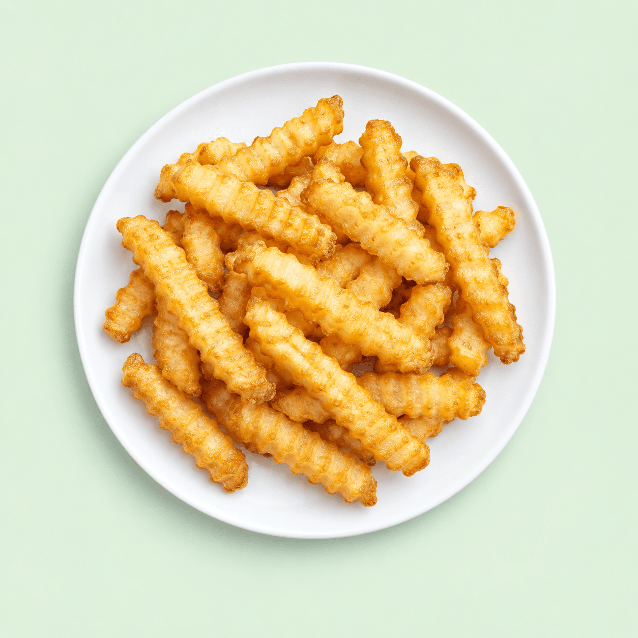 Golden crinkle cut chips on a white plate