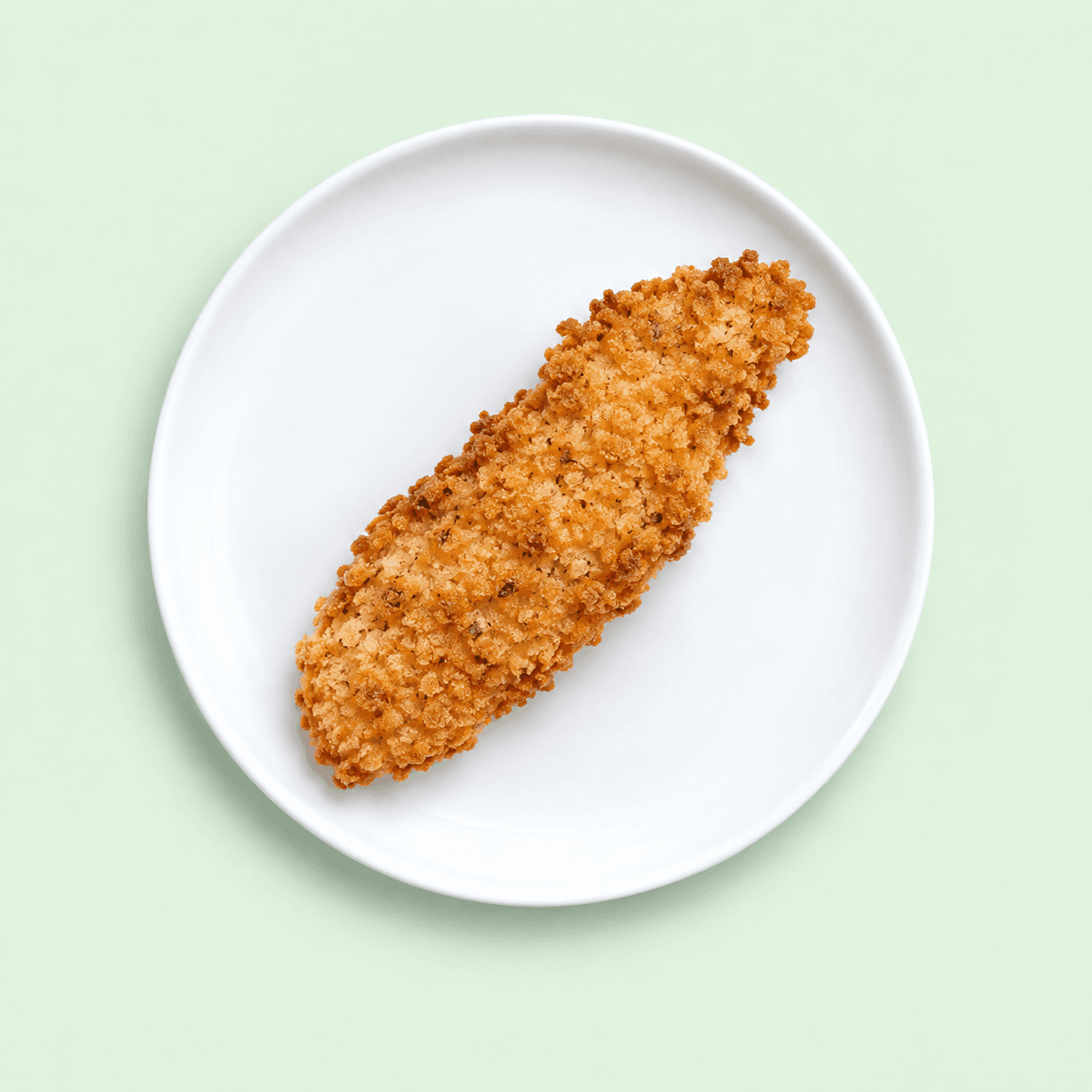 Crisp crumbed chicken tender on a white plate