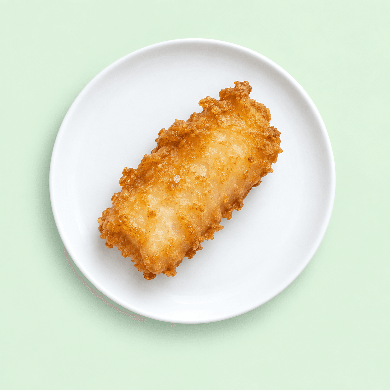 Golden battered fish bite on a white plate