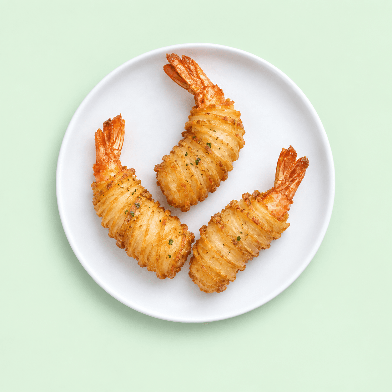 Three crisp prawn twisters on a white plate