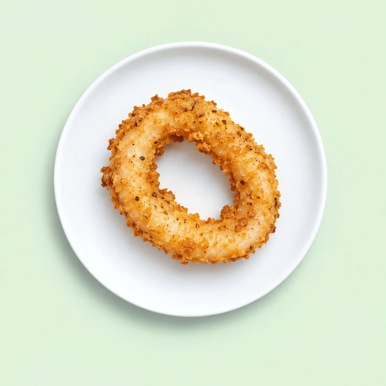 Golden crumbed squid ring on a white plate